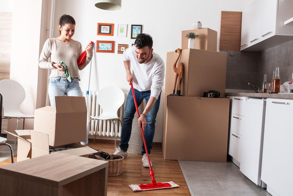 Young man mopping floor while young woman cleans